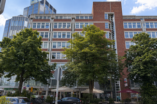 Mehrgeschossiges Bürogebäude in Düsseldorf mit Klinker- und Glasfassaden sowie begrüntem Straßenraum